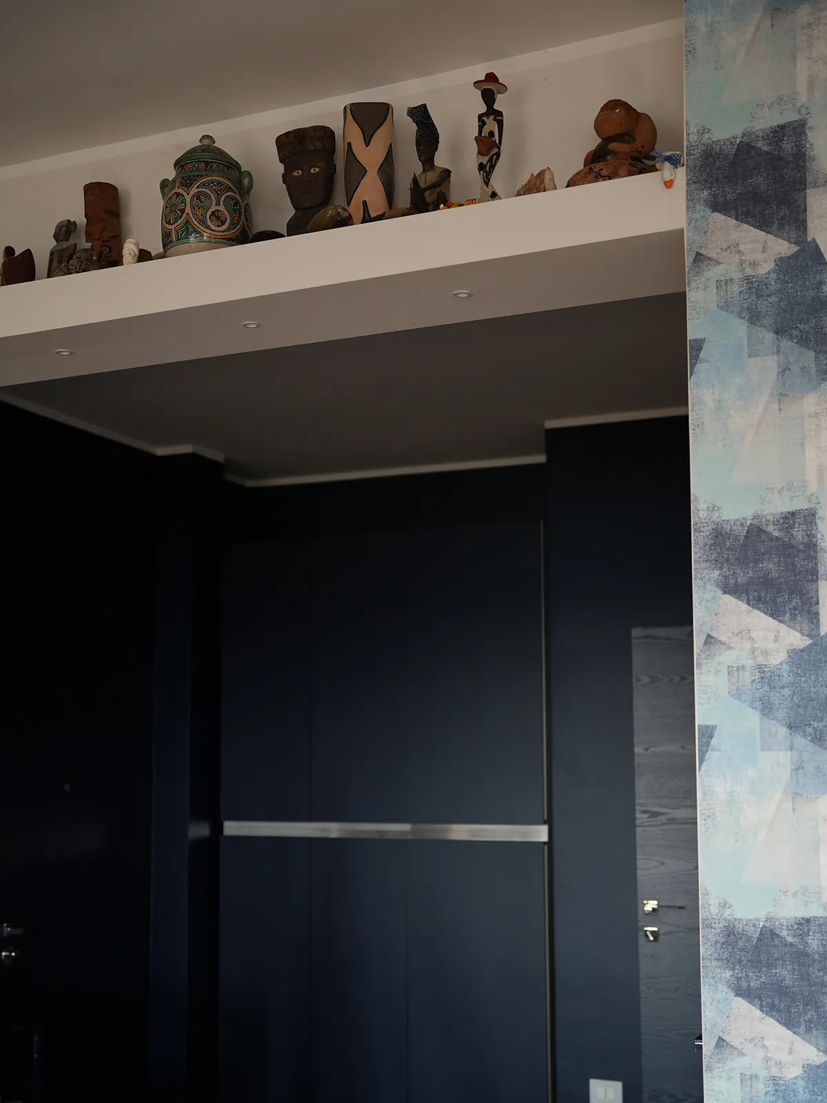 Arredo su misura blu con oggetti decorativi in appartamento ristrutturato a Torino