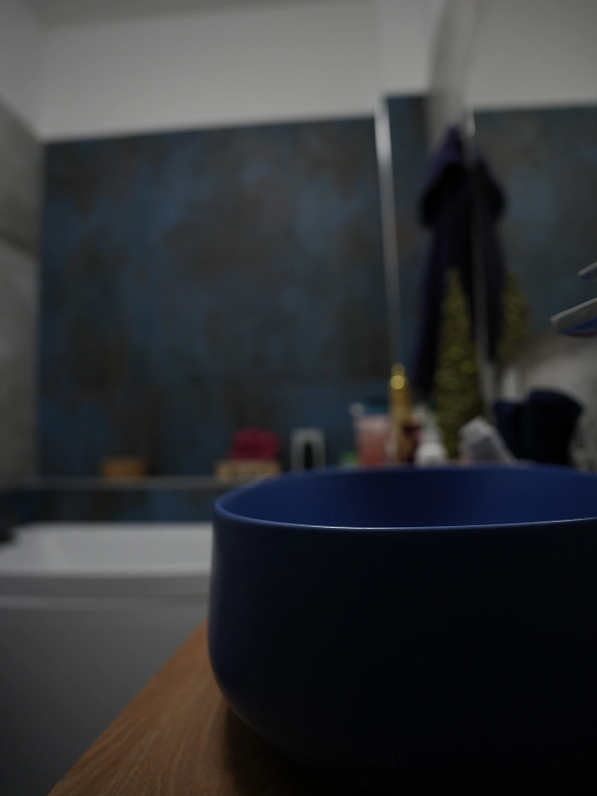 Bagno con lavabo blu e rivestimenti materici in progetto di interior design a Torino