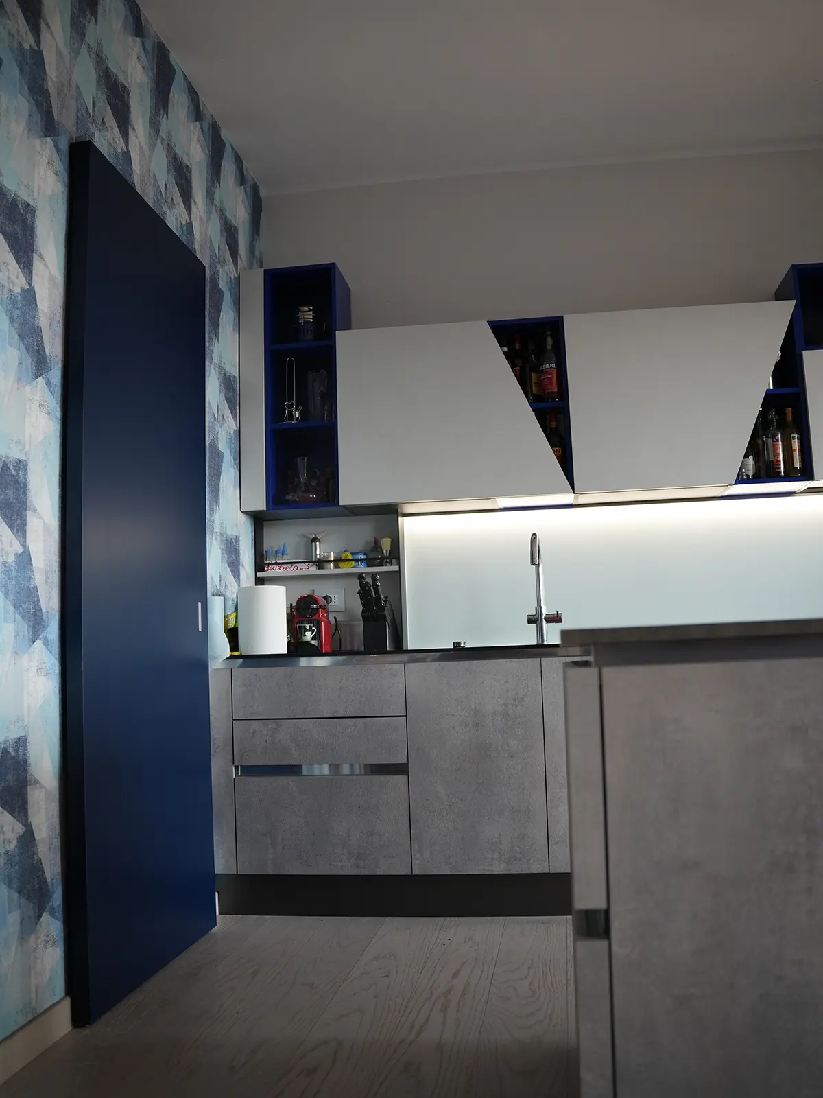 Dettaglio dei volumi della cucina con finiture materiche e contrasti cromatici a Torino