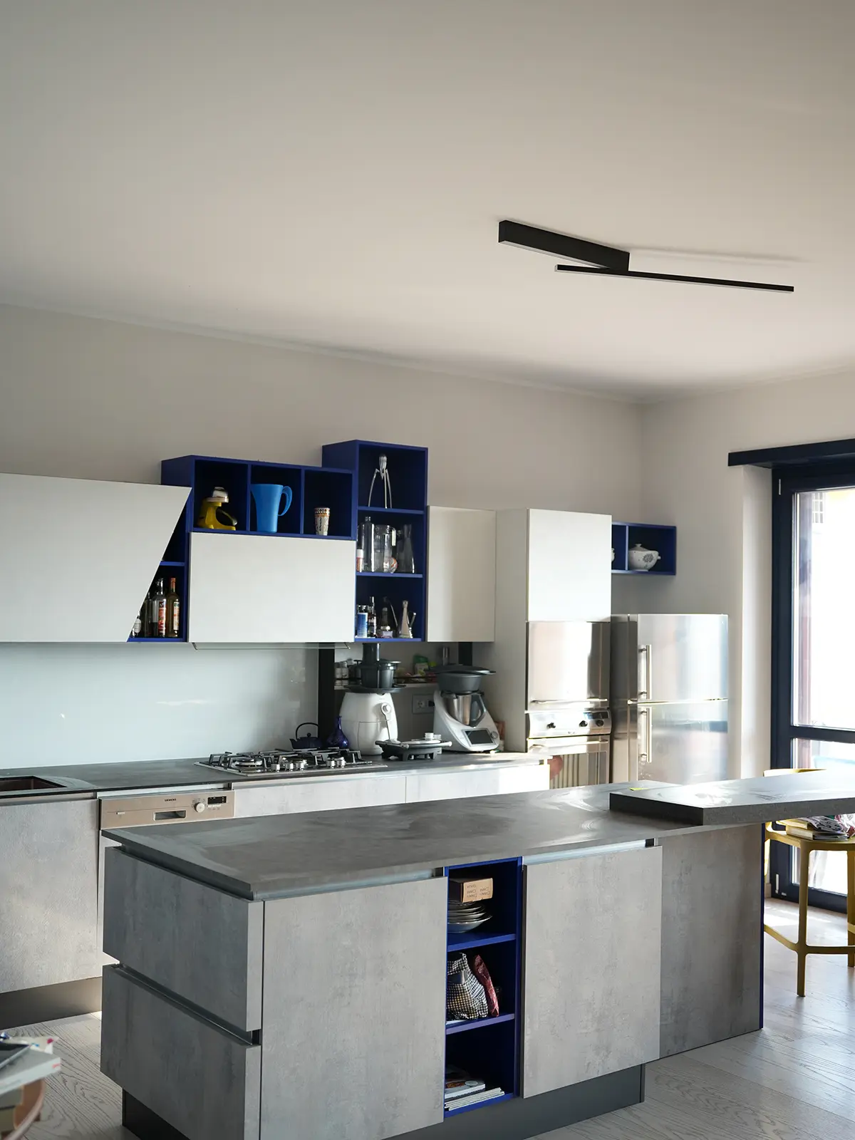 Cucina moderna con isola centrale e contrasti cromatici in progetto di interior design a Torino