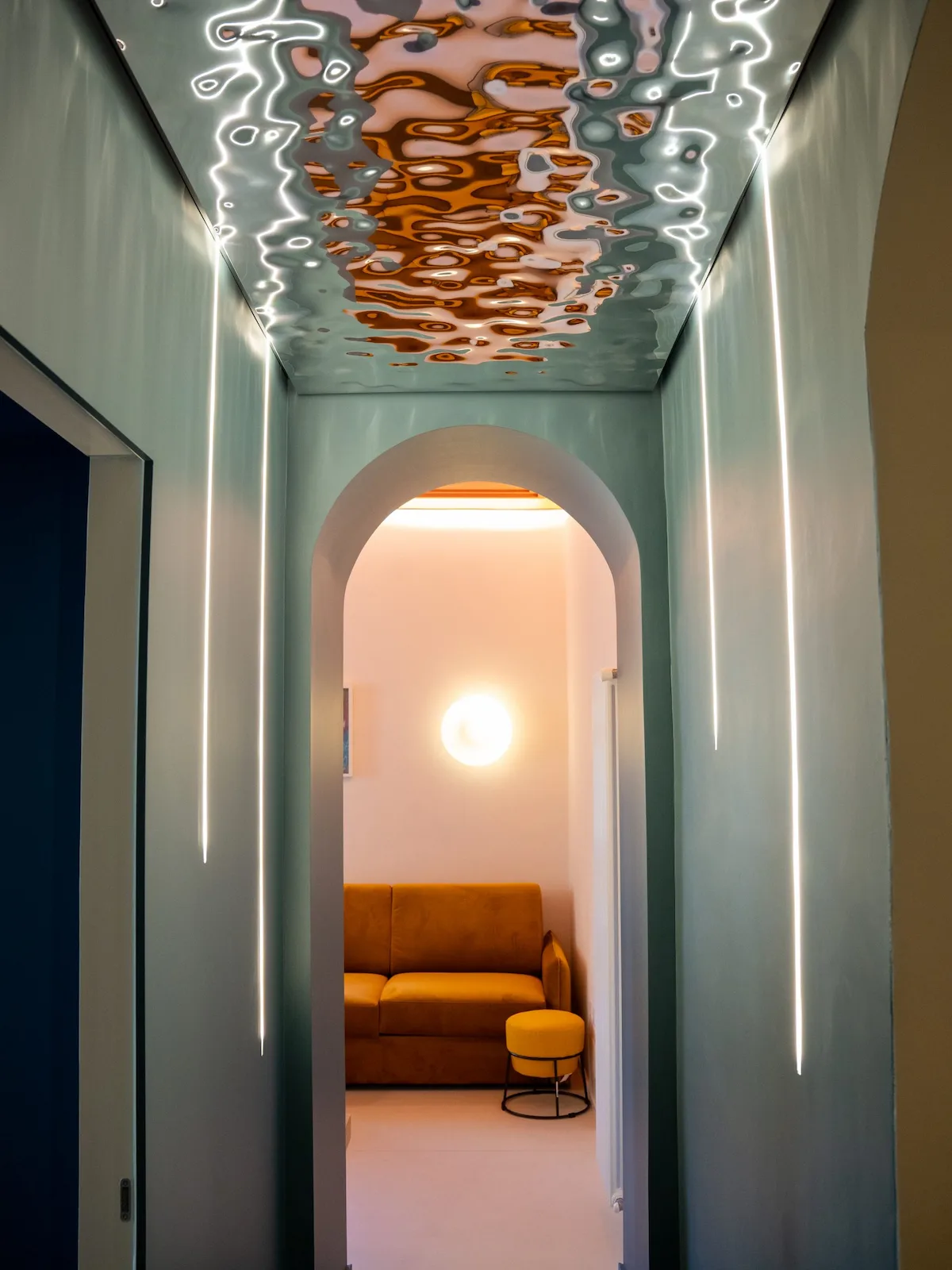 Corridoio con arco architettonico e illuminazione verticale in un progetto di ristrutturazione e interior design a Torino