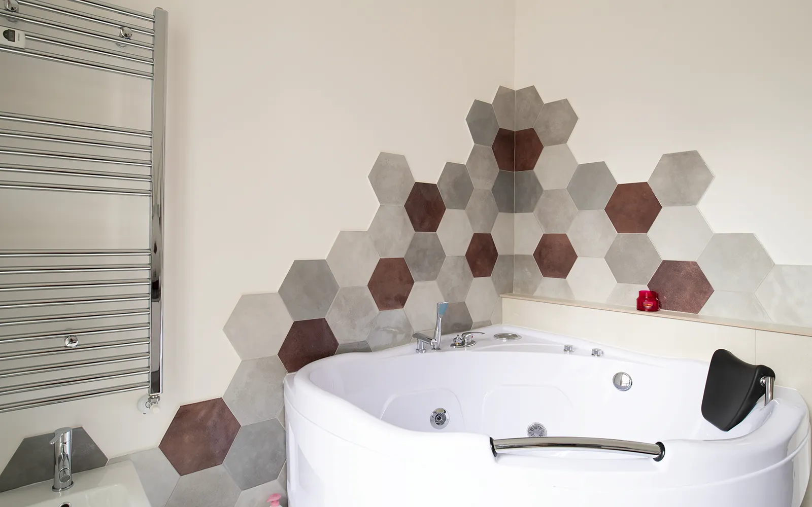 Area bagno con vasca idromassaggio e rivestimento geometrico esagonale in appartamento contemporaneo a Torino