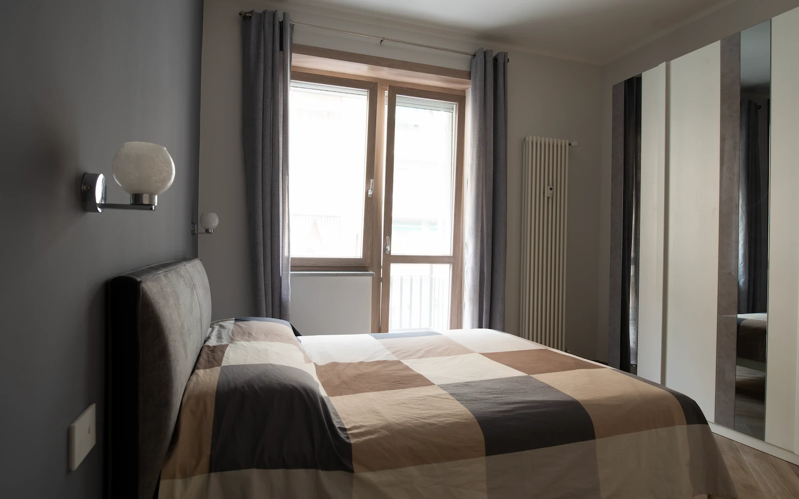 Camera da letto moderna con palette neutra e luce naturale in appartamento ristrutturato a Torino