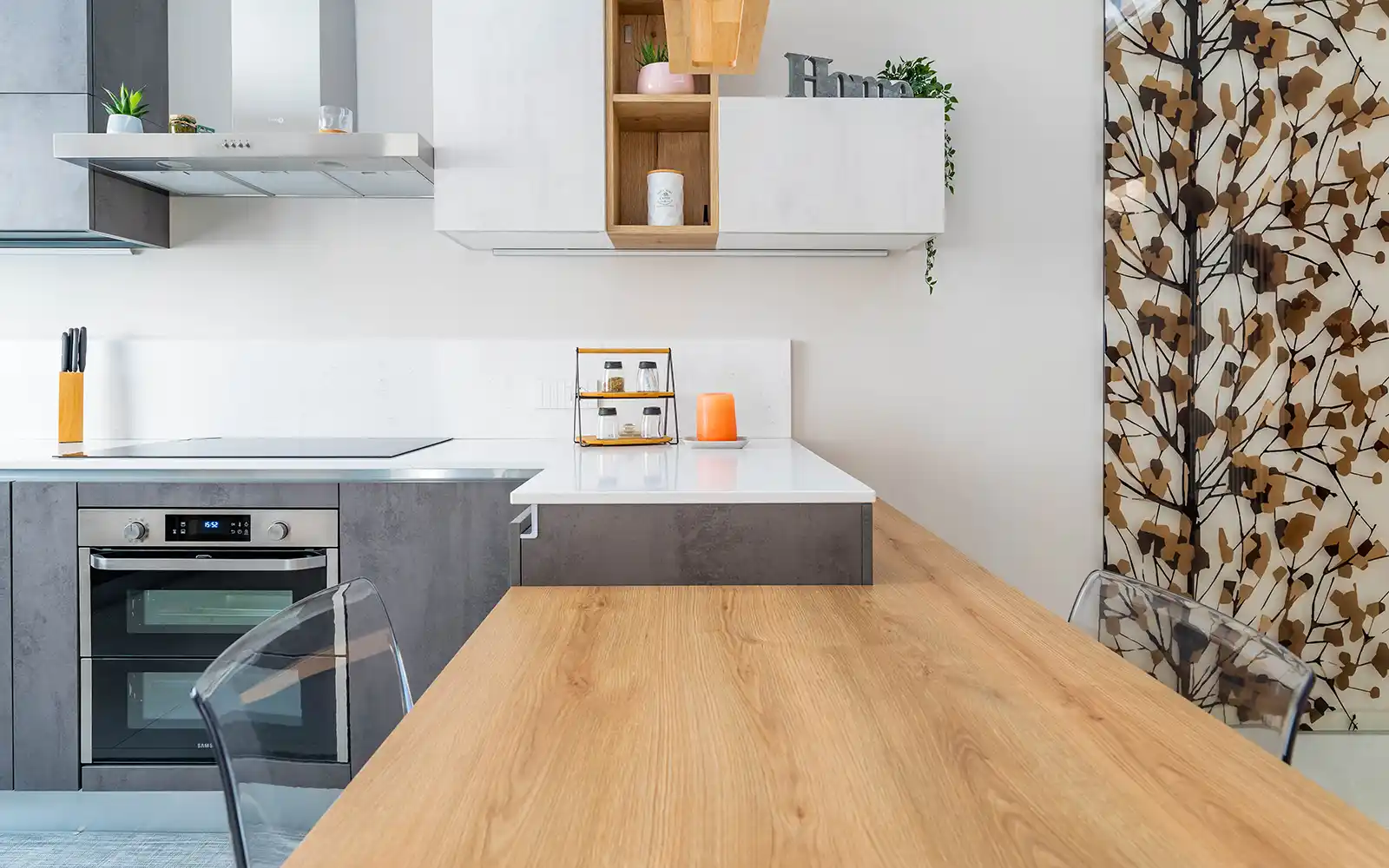 Dettaglio della cucina contemporanea con penisola in legno e finiture materiche in appartamento a Torino