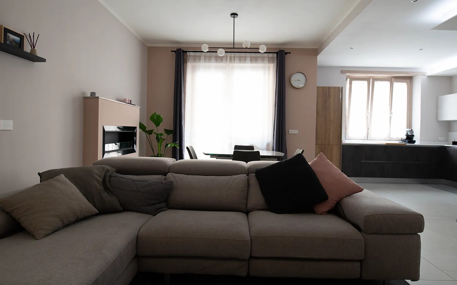 Living open space con cucina integrata e palette neutra in appartamento ristrutturato a Torino