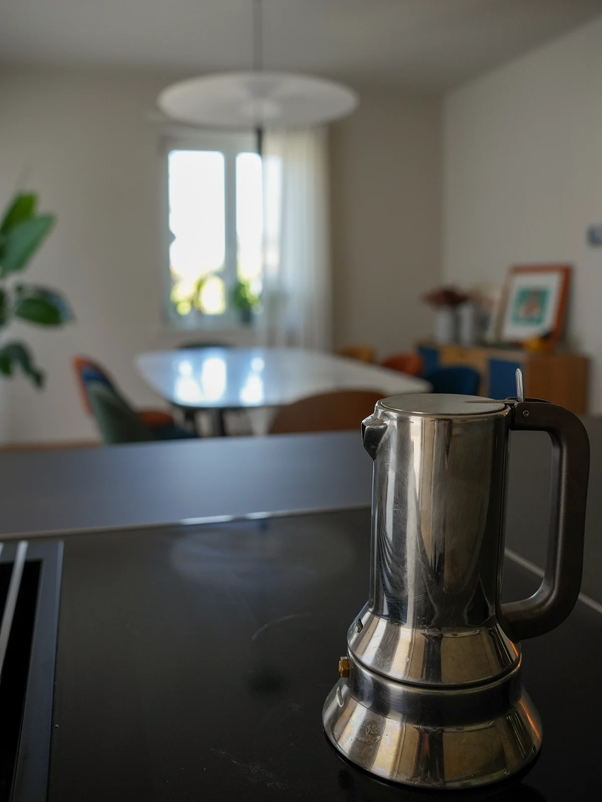 Dettaglio piano cucina con moka e sfondo sala da pranzo in un progetto di interior design contemporaneo a Torino