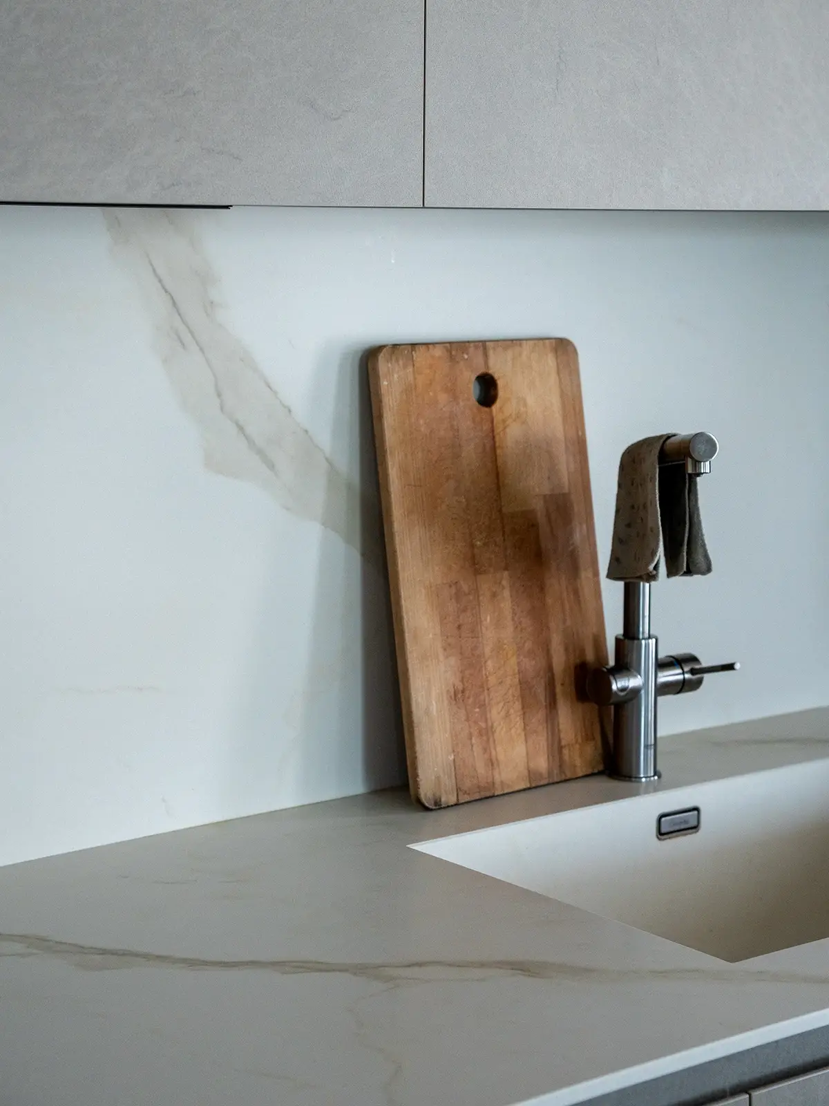 Dettaglio del piano cucina effetto marmo con lavello integrato e rubinetteria in acciaio in un appartamento ristrutturato a Torino