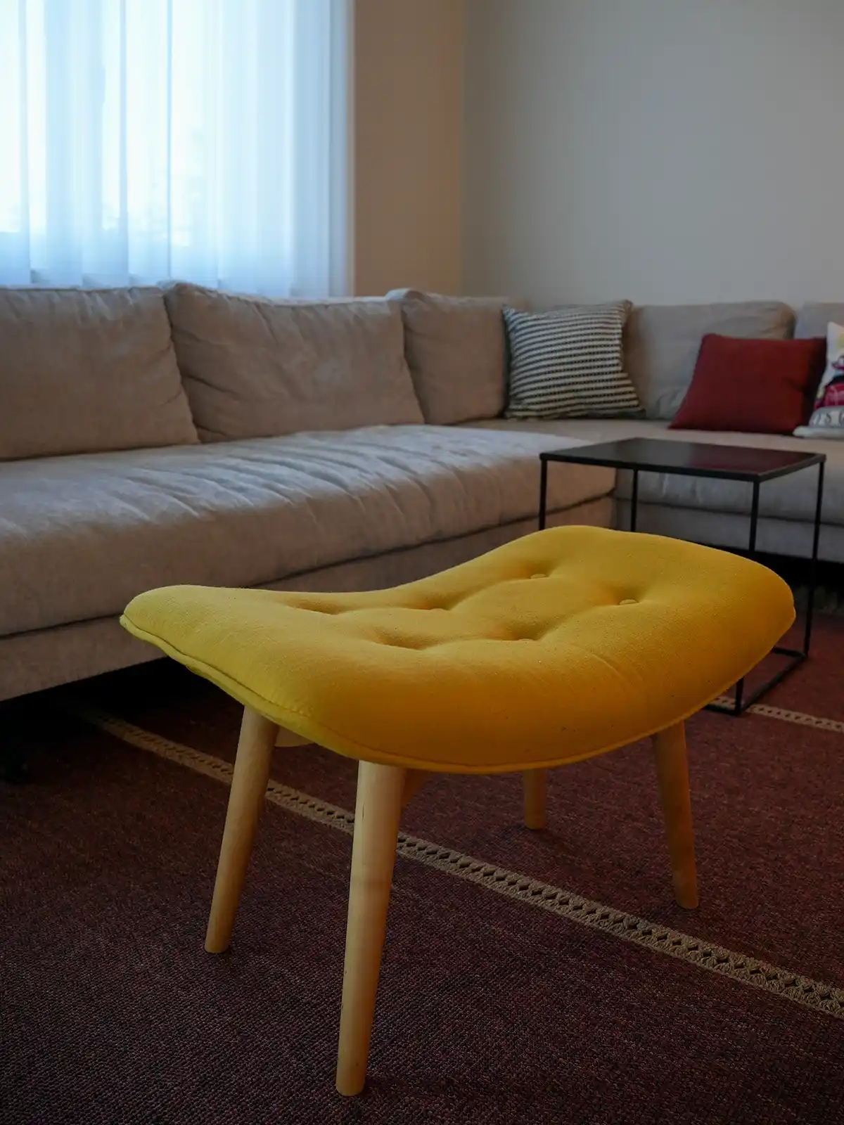 Dettaglio pouf di design giallo su tappeto e parquet in un progetto di interior design residenziale a Torino