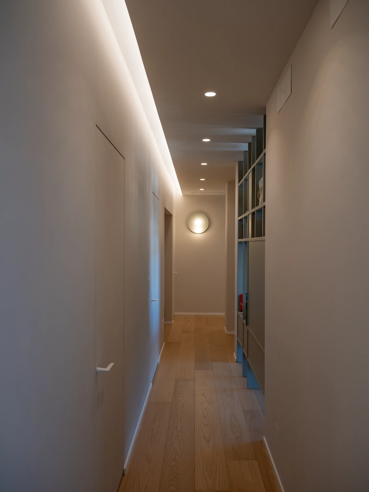 Ingresso contemporaneo in un progetto di interior design a Chieri con illuminazione architettonica, arredi integrati e palette neutra minimalista.