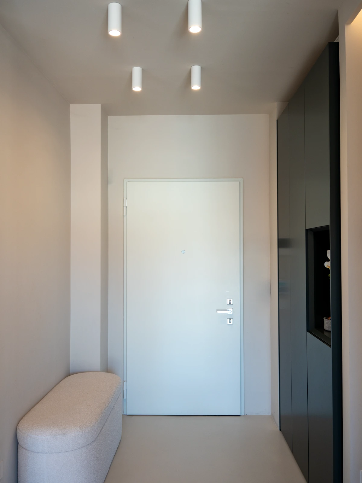 Corridoio contemporaneo in un progetto di interior design a Chieri con illuminazione lineare integrata, pavimento in legno e arredi su misura lungo il percorso distributivo.