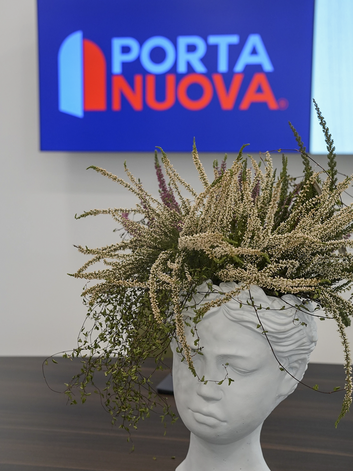 Dettaglio decorativo all&rsquo;interno dello showroom Porta Nuova a Torino con composizione floreale artistica e interior design contemporaneo.