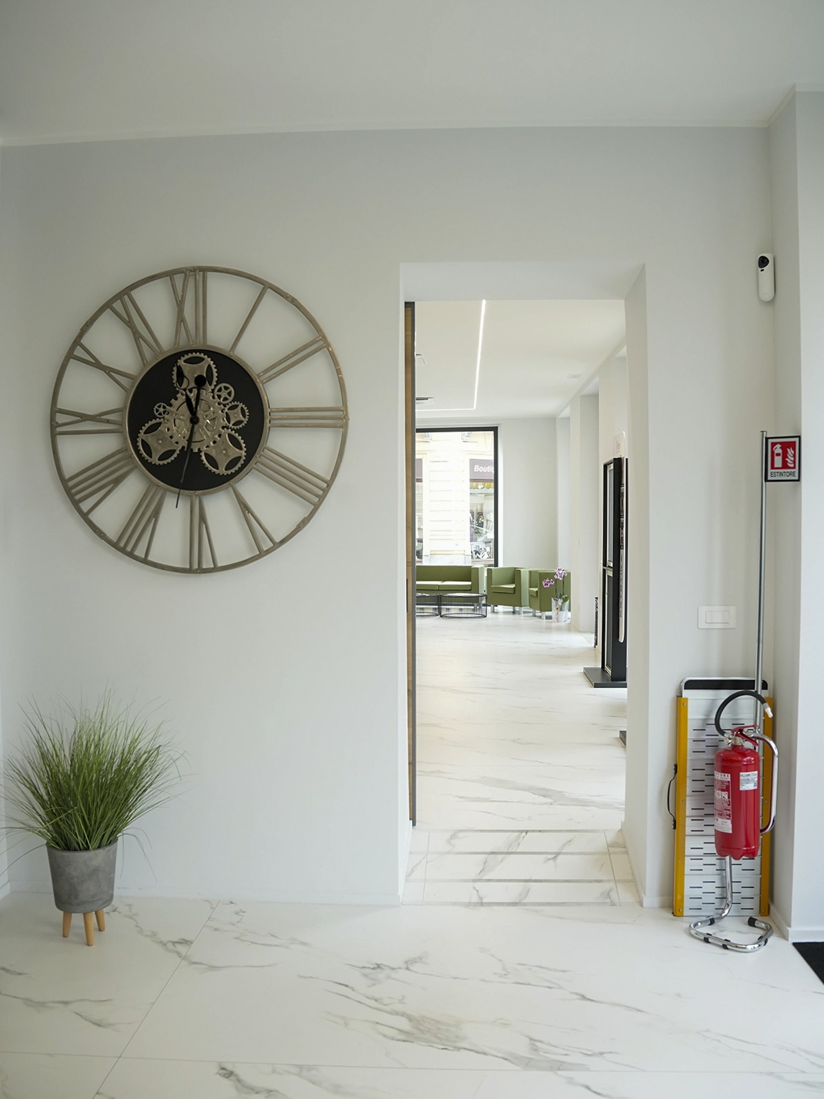 Ingresso dello showroom Porta Nuova a Torino con pavimento effetto marmo, dettagli decorativi e interior design minimal contemporaneo.