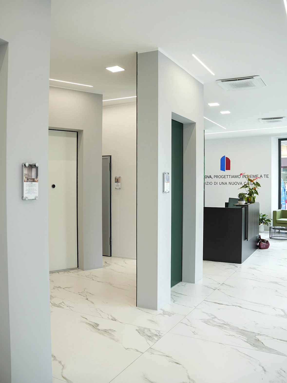 Vista degli interni dello showroom Porta Nuova a Torino con pavimento effetto marmo, reception moderna e percorsi espositivi dal design contemporaneo.