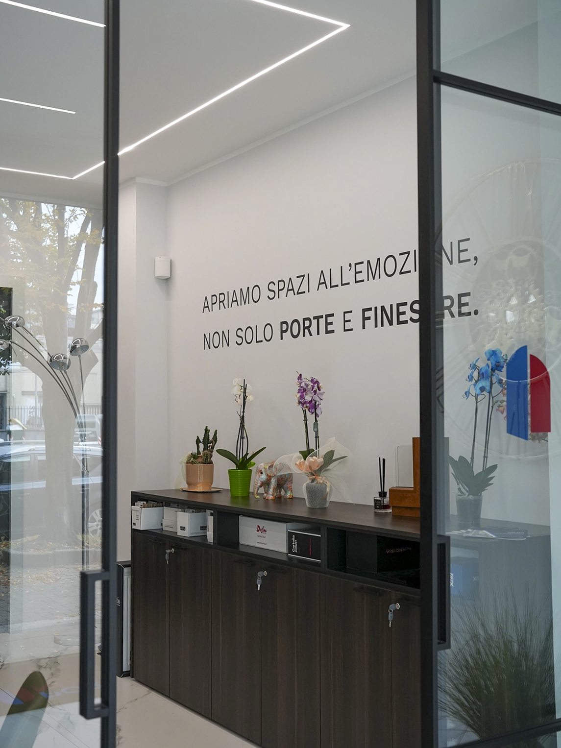Ingresso dello showroom Porta Nuova a Torino con arredi su misura, pareti minimal e interior design contemporaneo dedicato a porte e serramenti.