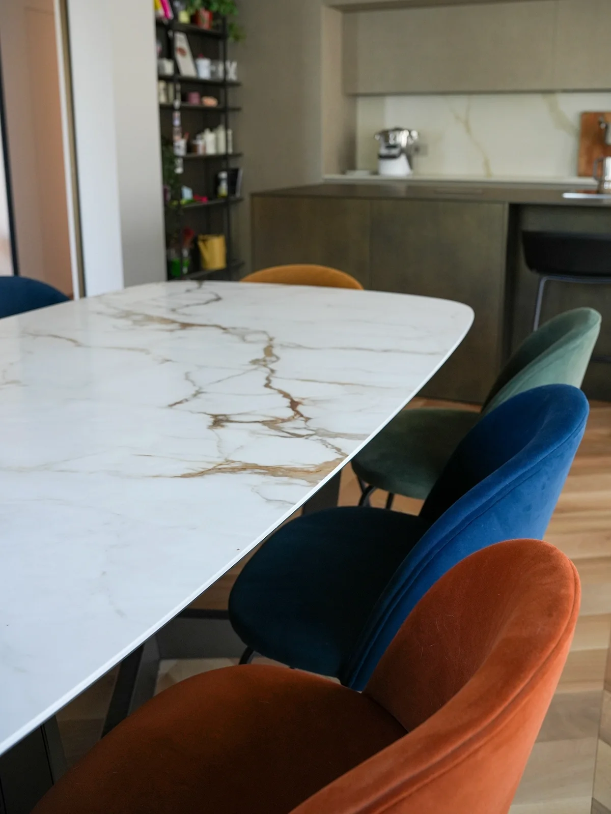 Dettaglio tavolo effetto marmo con sedute colorate in velluto in un ambiente dining progettato a Torino