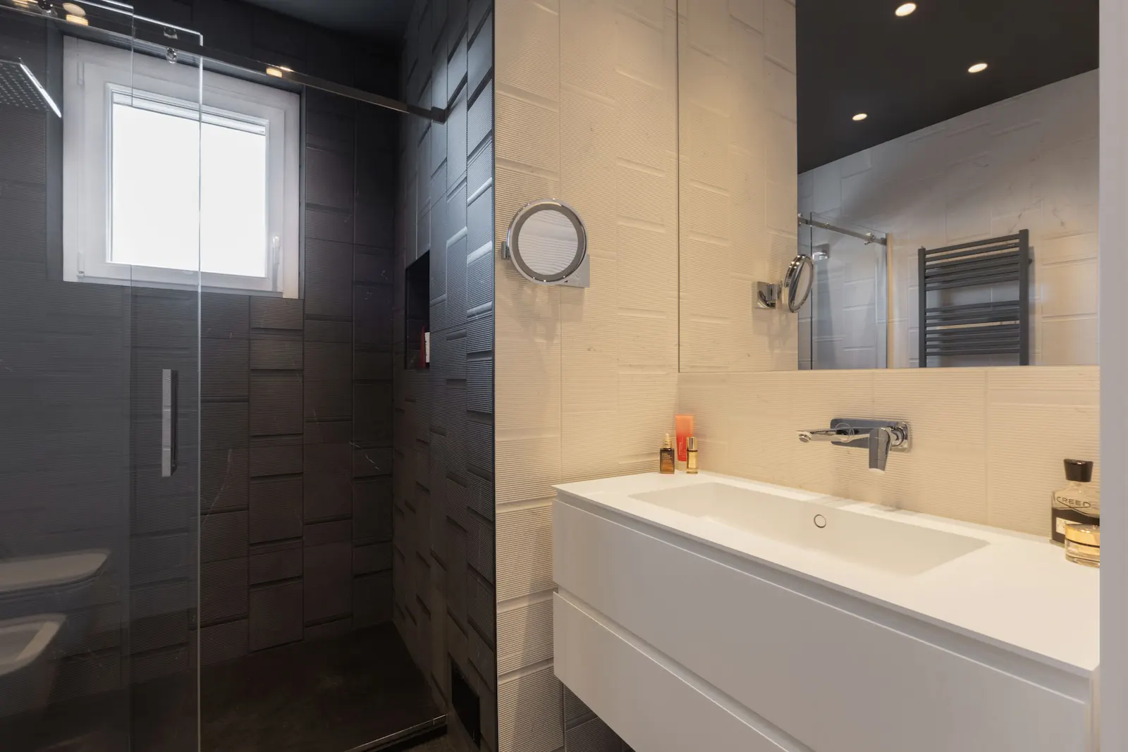Bagno ospiti con rivestimenti a contrasto e doccia.