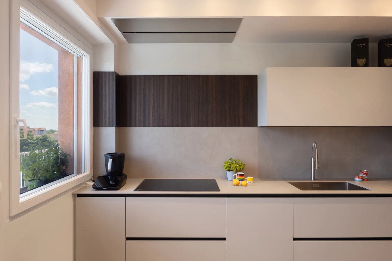 Cucina lineare minimal con piano a induzione e arredi su misura.