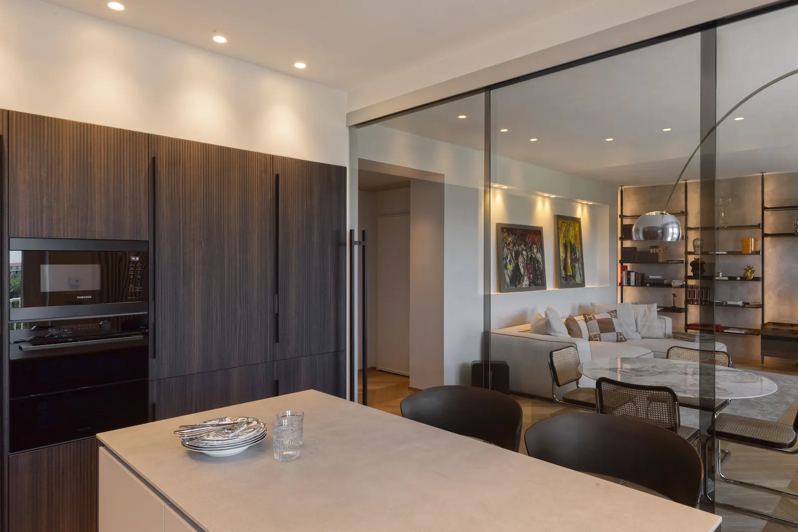 Cucina contemporanea con vetrata scorrevole fumé che separa la zona giorno.