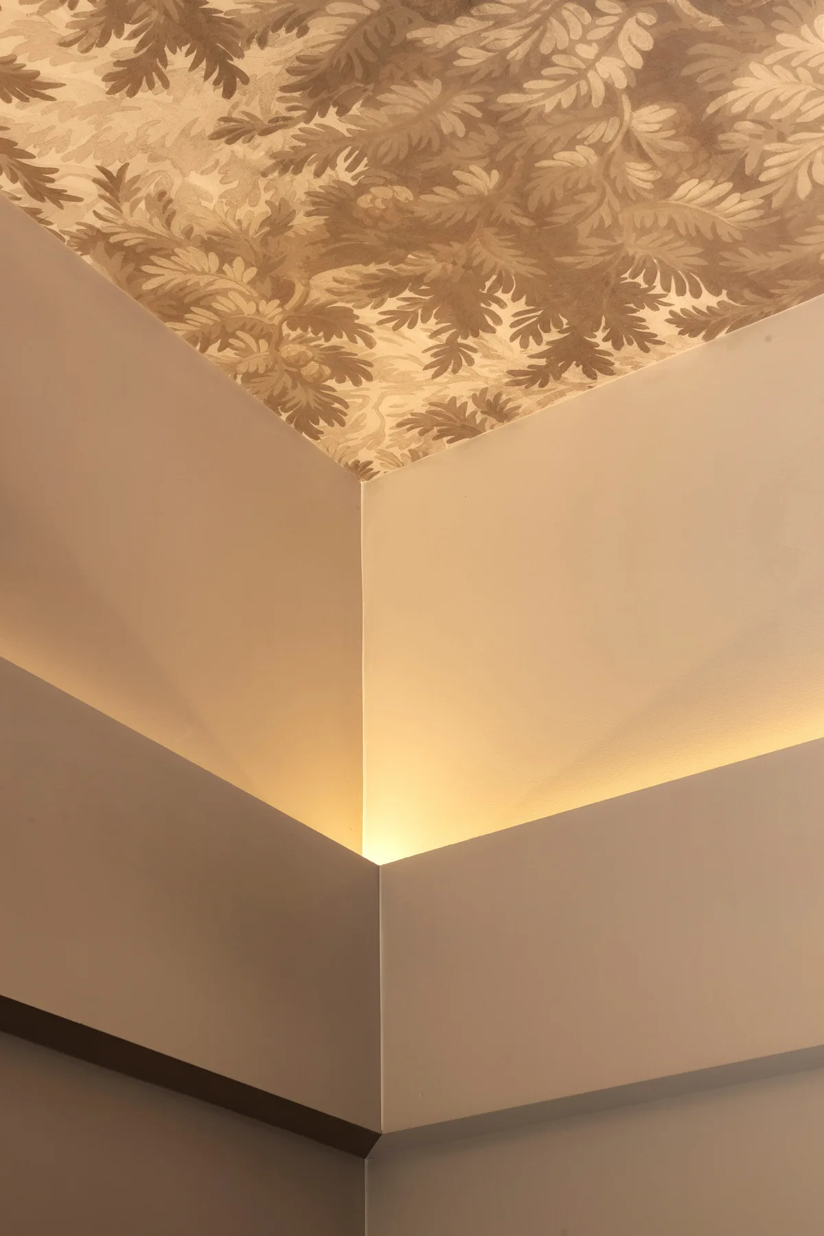 Dettaglio dell'illuminazione LED perimetrale e della carta da parati decorativa applicata al soffitto dell'agenzia di pompe funebri.