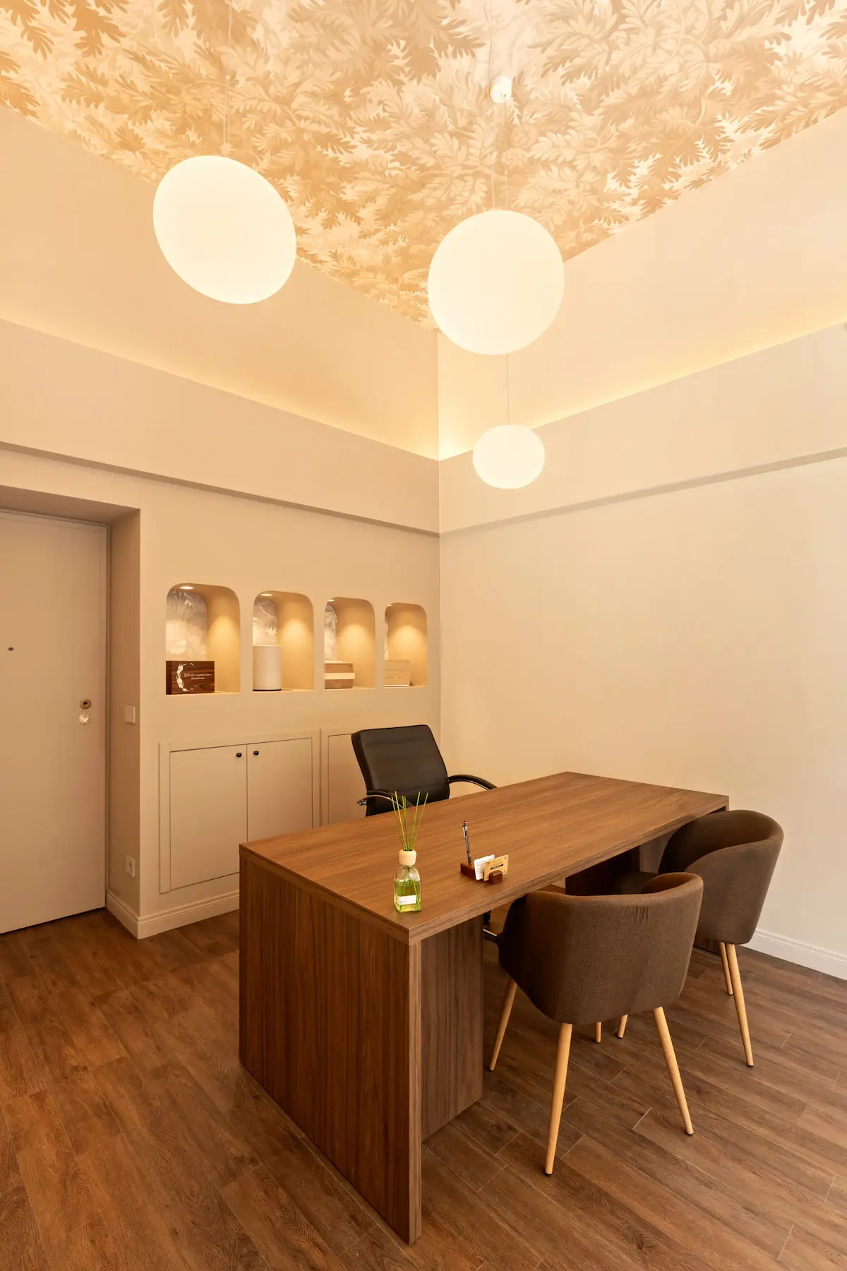 Vista laterale dell'ufficio di un'agenzia di pompe funebri progettato con materiali naturali, illuminazione calda e arredi essenziali.