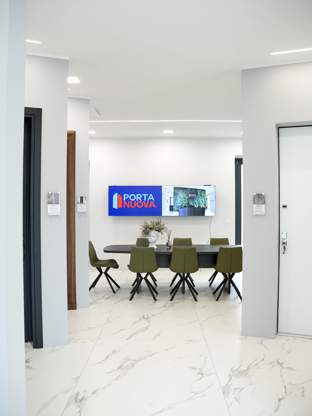 Vista interna dello showroom Porta Nuova a Torino con pavimento effetto marmo, sala riunioni moderna e interior design minimal contemporaneo.