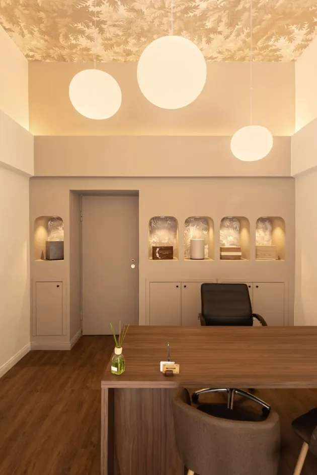 Progetto di interior design per un'agenzia funebre a Torino con illuminazione a sospensione, nicchie espositive e arredi su misura.