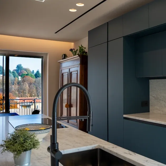 Cucina moderna blu con lavello e finestra in un progetto di interior design residenziale a Chieri